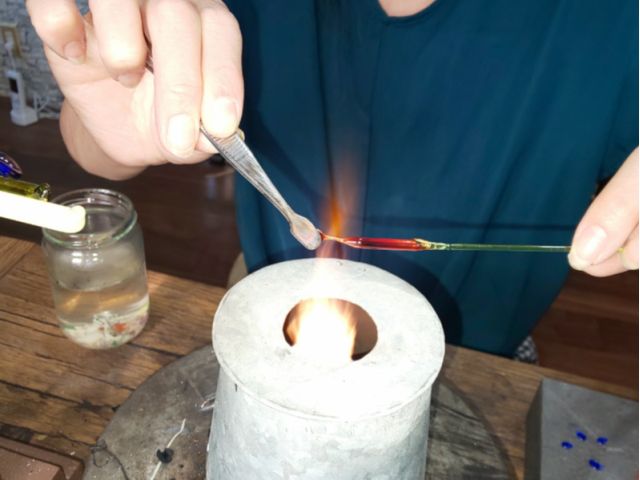 @灯油バーナーで細引きガラスを熱してオハジキを作ります。
