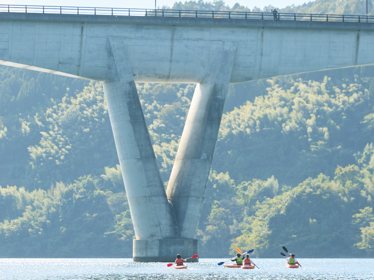 V字の橋桁が印象的な「苫田大橋」をバックに記念撮影。