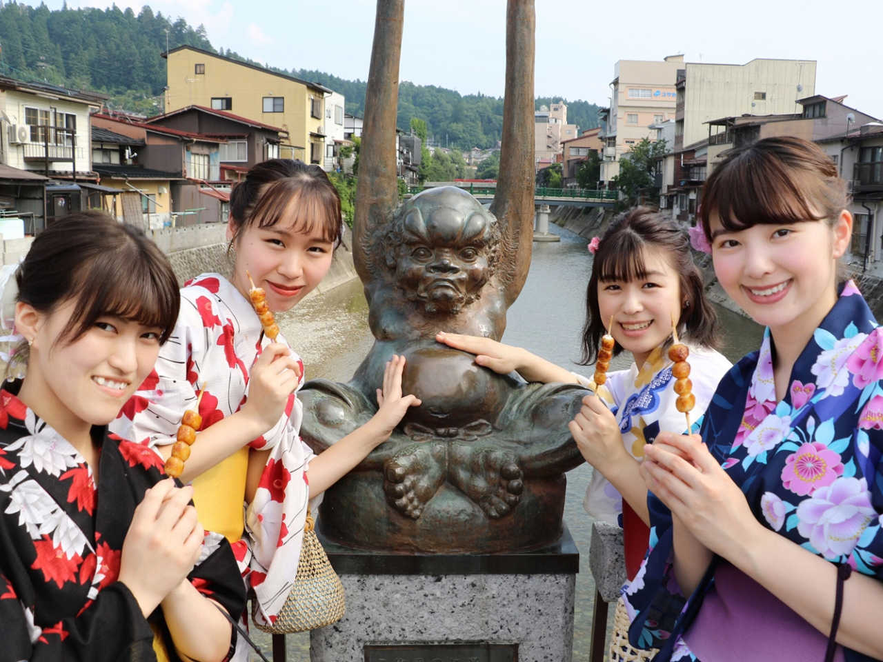 てなが像の前でみたらし団子