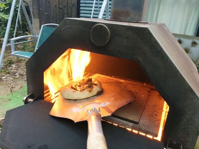 薪で焼く本格ピザ。市販品のピザを焼くだけでもウマウマ!ナンを焼いて、カレーと合わせるのも◎  薪のピザ窯(有料)