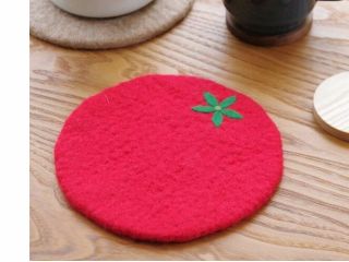 型にふわふわ羊毛を入れ、石鹸水をかけ、圧縮したら、よくすすいで、ヘタの模様をつけます。写真は飛騨トマト!柔らかい羊毛で大切な木のテーブルを守ります。