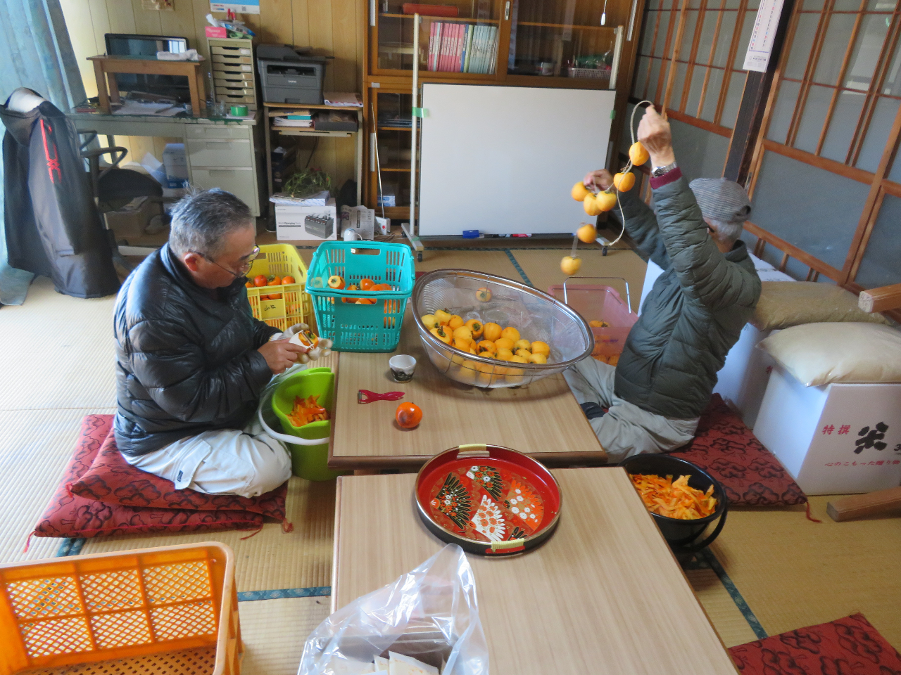 もぎ取った柿の皮をむき、吊るして乾燥させる準備作業