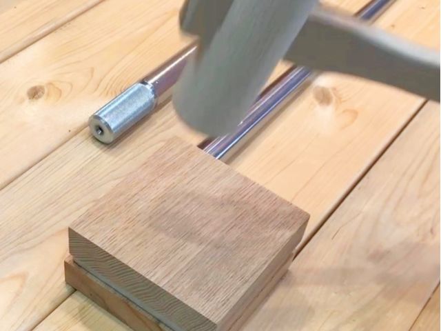 作業工程で歪みができたリングを、硬い木材のケヤキを間にして木づちで打ち、形を整えます