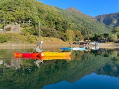周囲の山々を映し出す、鏡のように静かな早朝の湖