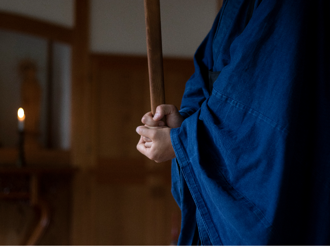 坐禅の間、住職が警策(修行者の肩や背中を打つための棒)を持って歩きます