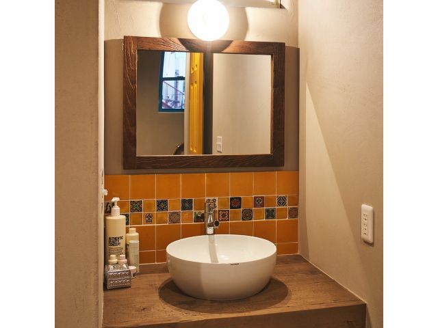 メキシコのタイルを敷き詰めた洗面台のあるパウダールーム。 フェイスケアにはKISKANUのCBDオイルをお使いください。