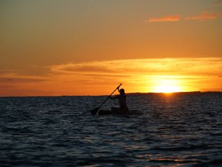 宮古島の水平線に沈む夕日をSUPの上から満喫。幻想的な景色と思い出を写真に残します。