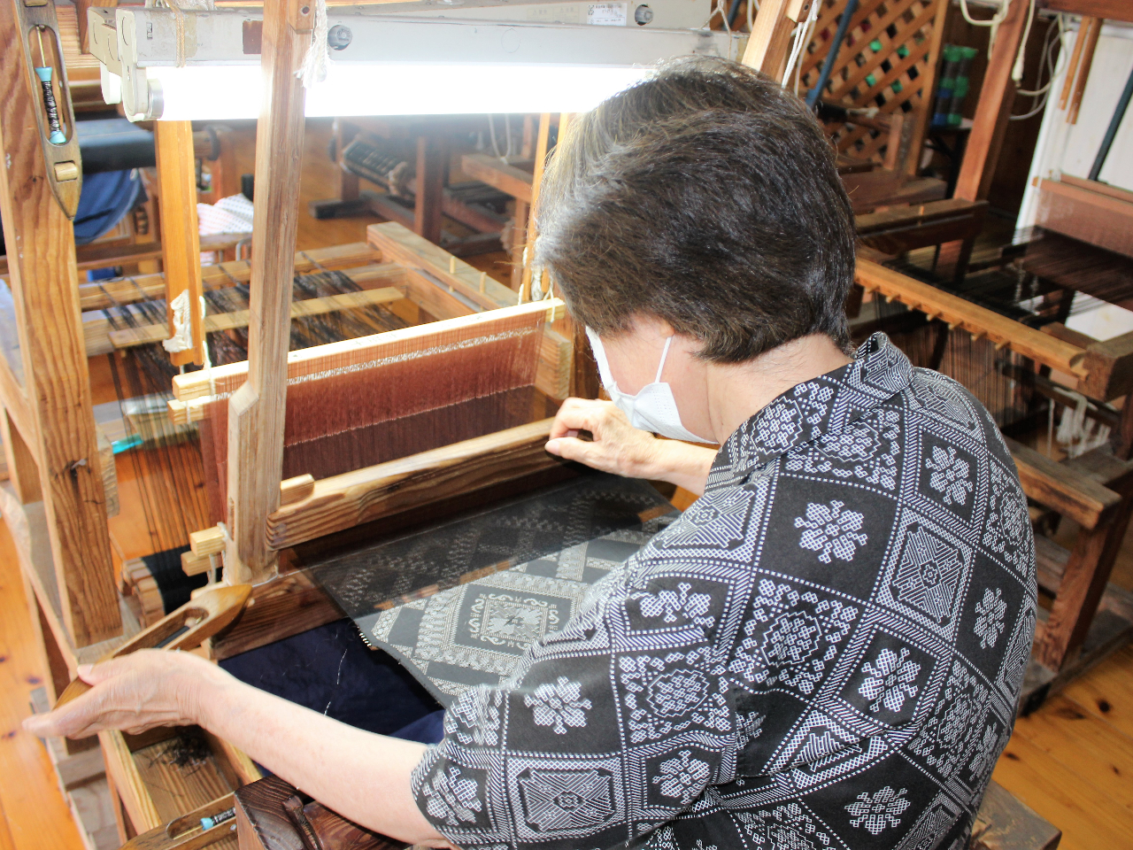 大島紬の織機で絣糸を織る伝統の手仕事
