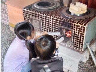 昔ながらの釜戸で薪を燃やしてご飯を炊きます。