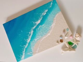 A4サイズのアートパネルに、沖縄のサンゴの砂を張り、青い海のレジンと白い波が綺麗です。砂浜に貝殻やシーグラスを飾って完成!!
