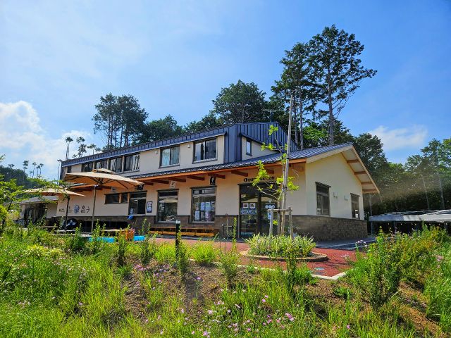 BBQの受付と食材を販売している管理棟。奏の森リゾート内で唯一「2階建て」の建物が目印です。BBQテントは管理棟の写真右側に点在しています。