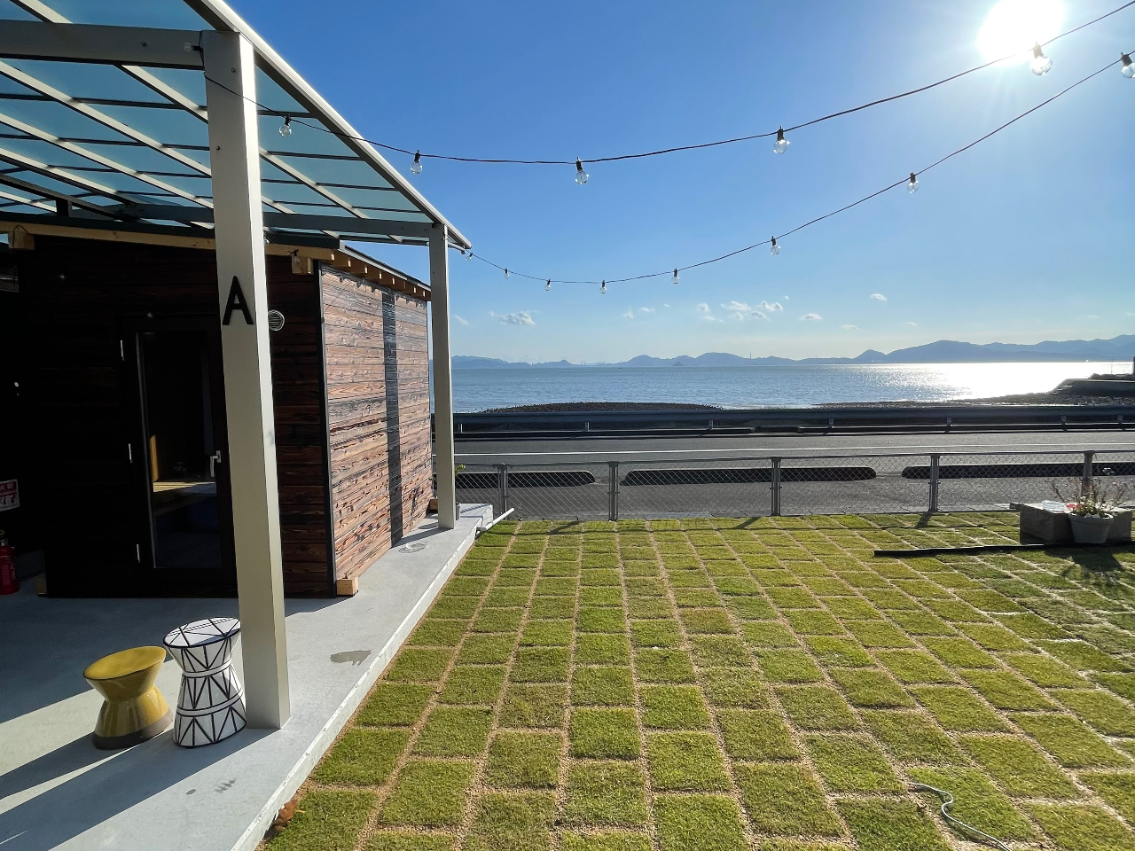 サウナ、水風呂に入った後の外気浴はこちらで芝生スペースで瀬戸内の海を見ながらごゆっくりおくつろぎください