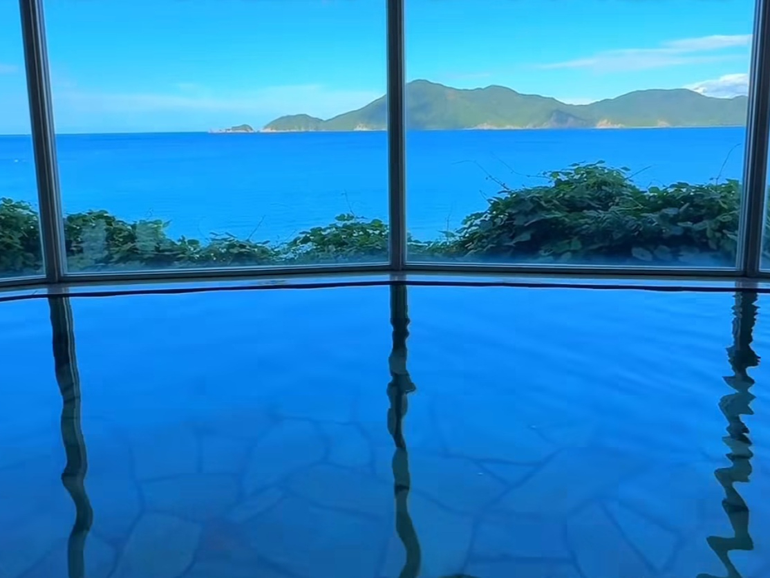 【悠久の湯/オーシャンビュー展望大浴場】肌を優しく包む美肌の湯と、青海島を望む静かな湯処。陽光に輝く青い海も、雨に霞む穏やかな水平線も、すべてが心をほどく景色。