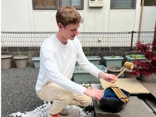 Ritual purification at the tsukubai water basin prior to entry.