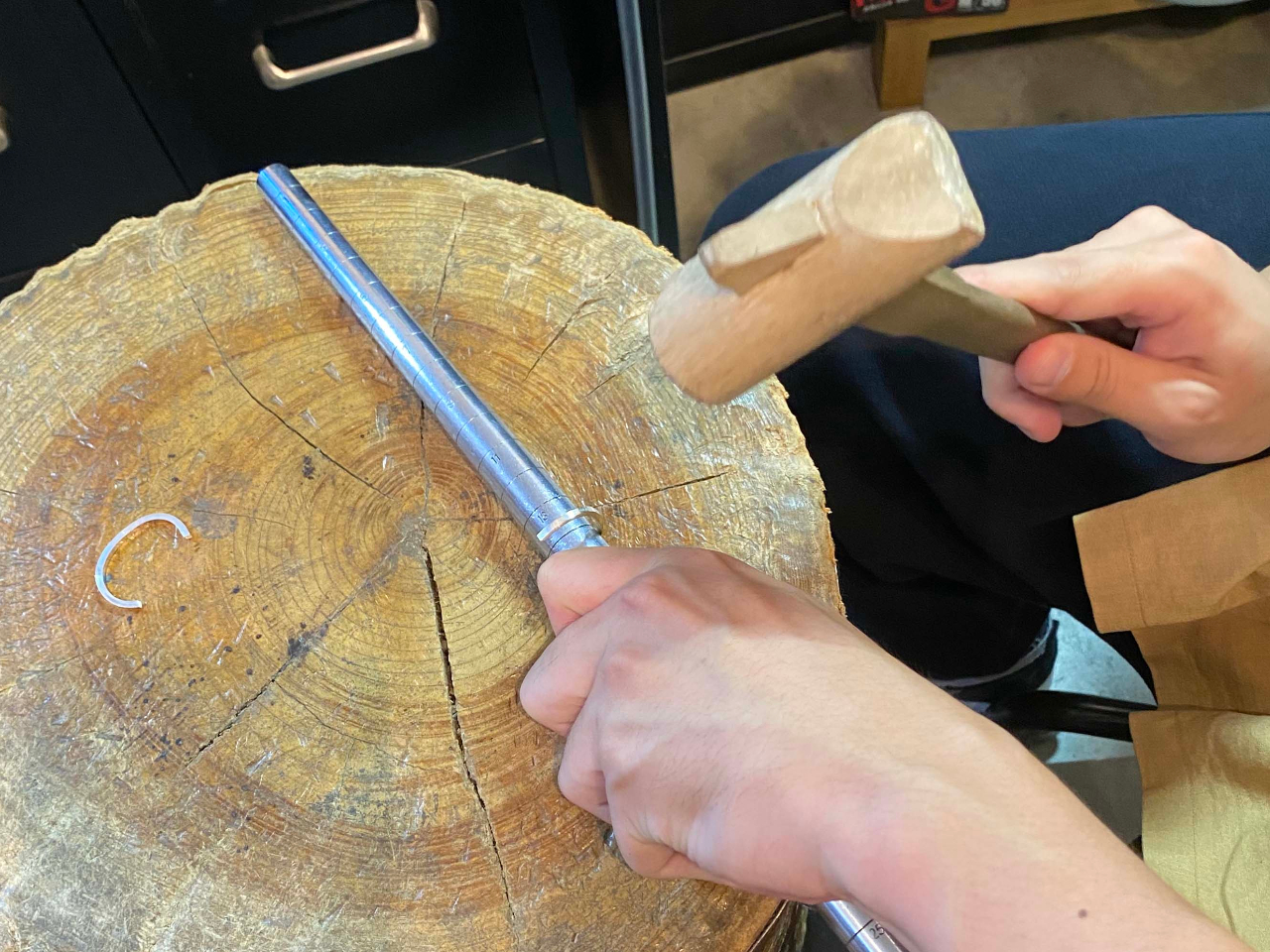 木槌を使って、銀の棒が丸い輪の形になるように少しずつ曲げていきます