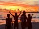 オレンジ色に染まる空と海をバックに仲間とポーズ!誰もいない空間でのサンセットは格別です。