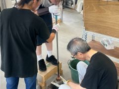 体験できる工程 Aガラス玉を型に入れて吹き棒から息を吹きかけて膨らませます