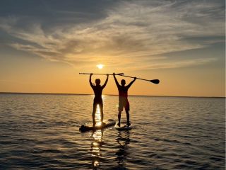 夕日に向かってパドルを掲げる“映える一枚”。