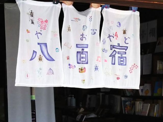 地域の皆さんの手を重ねて染めた温かな型染めのれんが目印