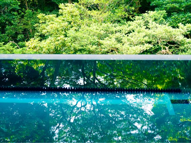 海と森を抜ける風が通り気持ちの良い自然光の入る屋根付き温水プール(6m×25m)