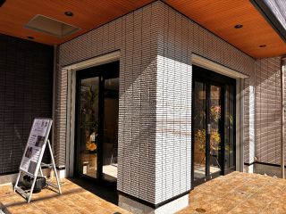 大宮門街裏の黒い建物1階。足元のタイルがベージュ、白黒の壁が目印です。