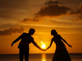 夕日に照らされたふたりのシルエットが美しいサンセットフォト。宮古島で過ごす特別な時間を幻想的に残します。