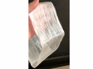 完成!自分で巻き取ったばかりの生糸をもっている様子です。驚くほど白く、気品ある輝きを放ちます。